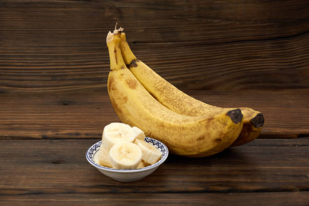 istock banana cluster isolated on wood background. 1191787897