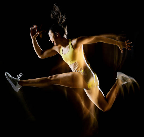 woman exercising fitness exercises isolated black background lightpainting effect one mixed race woman exercising fitness exercises isolated on black background with lightpainting effect lightpainting stock pictures, royalty-free photos & images