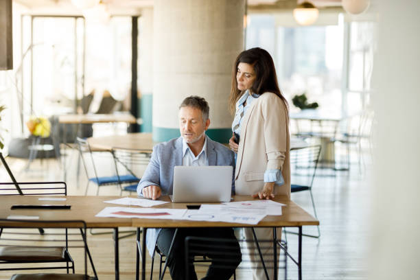 istock Coworkers discussing project on laptop 1191790316