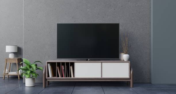 istock tv on cement wall in living room. 1191790420
