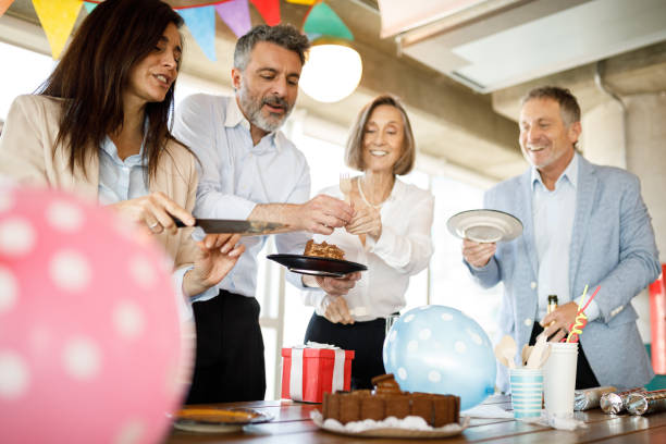 istock Coworkers eating birthday cake in office 1191790462