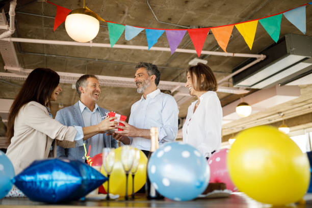 istock Coworkers giving birthday present 1191790553