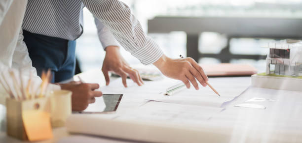istock Cropped shot of professional architect  working on the construction plan in modern office 1191790571