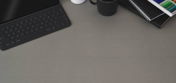 istock Top view of modern workplace with laptop computer and office supplies on dark grey table 1191790653