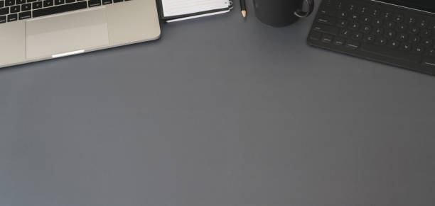 istock Top view of modern workplace with laptop computer and office supplies on dark grey table 1191790654