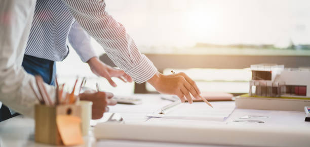 istock Close-up view of young professional architect and engineer working together on construction plans in modern office 1191790672