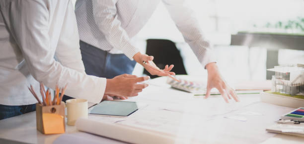 istock Close-up view of young professional architect team working on construction plans in modern office 1191790701