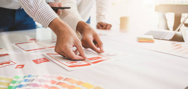 istock Close-up view of young professional UI app development team planing on smartphone template 1191790715