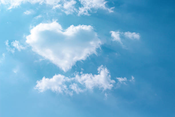 istock Clouds heart shaped patterns on bright blue sky with mild wind and reflection light from the sun for background 1191791701