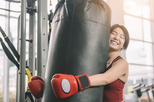 an asian chinese female teenager athlete wearing boxing gloves workout in gym during weekend
