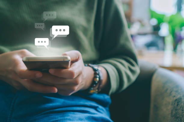 istock Women hand using smartphone typing, chatting conversation in chat box icons pop up. Social media maketing technology concept.Vintage soft color tone background. 1191798464