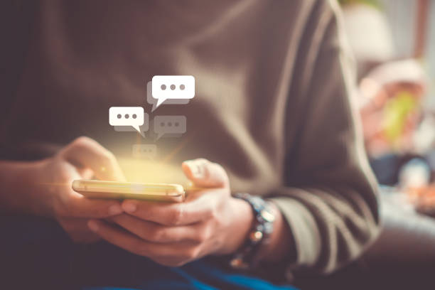 istock Women hand using smartphone typing, chatting conversation in chat box icons pop up. Social media maketing technology concept.Vintage soft color tone background. 1191798989