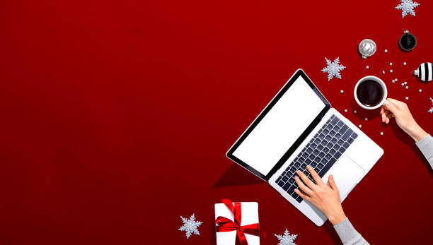 istock Christmas ornaments with person using a laptop computer 1191801832