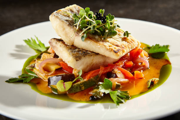 istock Pollock fish fillet with vegetables on white plate 1191802533