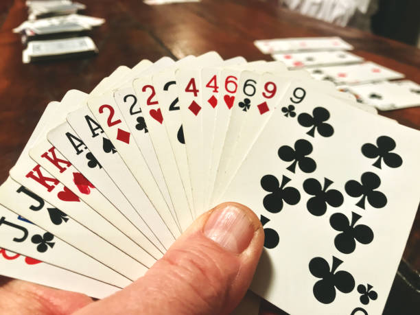 istock Male hand holding playing cards at table 1191802552