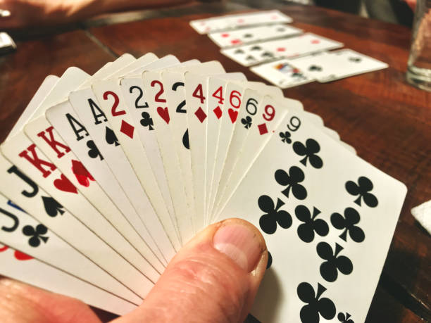 istock Male hand holding playing cards at table 1191802571