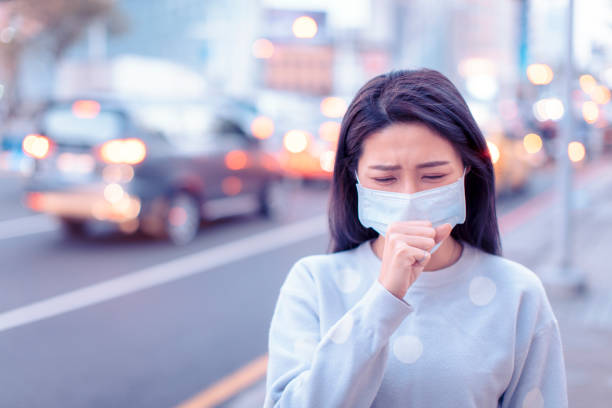 молодая женщина носить маску в городе в течение дня смога - pollution street city street fog стоковые фото и изображения