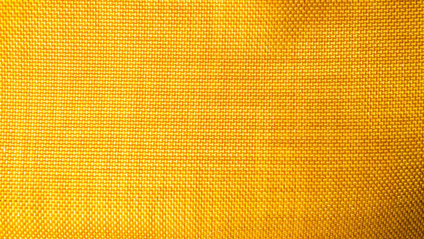 istock orange background from a textile material with wicker pattern, closeup. Structure of the bright  fabric with texture. Cloth backdrop with vignette. 1191808373