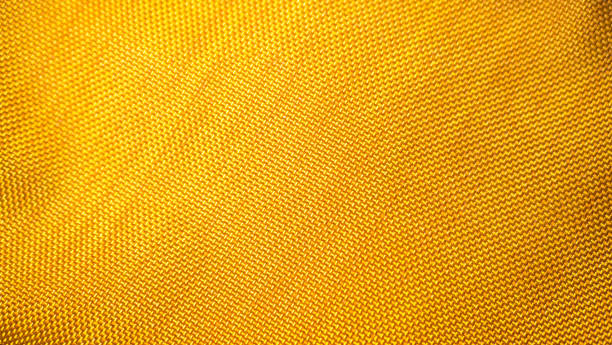 istock orange background from a textile material with wicker pattern, closeup. Structure of the bright  fabric with texture. Cloth backdrop with vignette. 1191808968