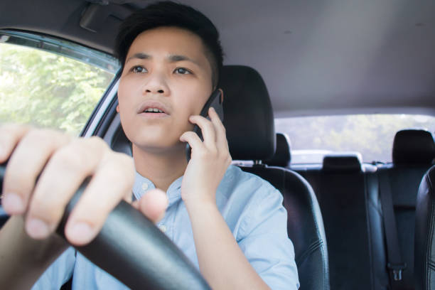 istock Front view of Asian people using mobile phones and having conversations while driving. 1191809080