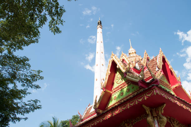 Ko Samui Island, Thailand - March 18, 2019: Wat Laem Suwannaram Chinese Buddhist Temple. Wat Plai Laem shrine on its platform upon pink lotus upon lake under blue cloudscape. Green forest in back.