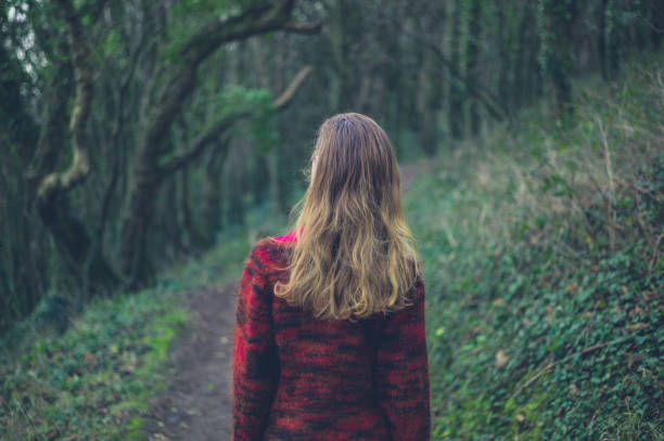 istock Young woman walking in the woods 1191811662