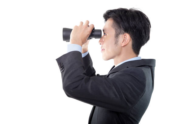 istock Side View of Businessman Looking Through Binoculars on White Background 1191813031