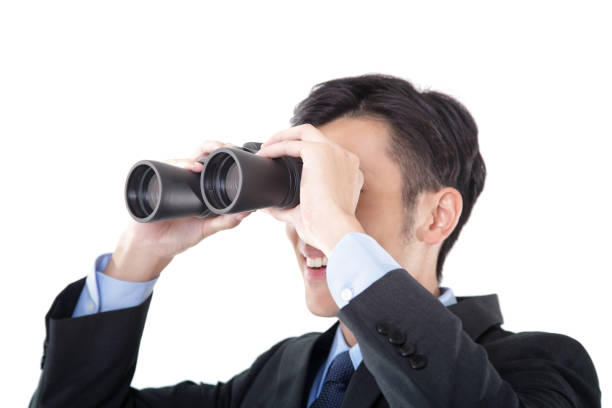 istock Close-up of Businessman Looking Through Binoculars on White Background 1191813036