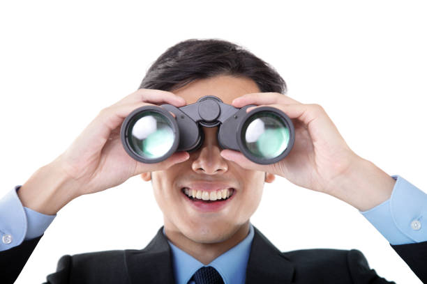 Close-up Front View of Businessman Looking Through Binoculars on White Background.