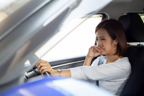 joven asiática sostiene su nariz debido al mal olor sucio en el coche - smell fotografías e imágenes de stock