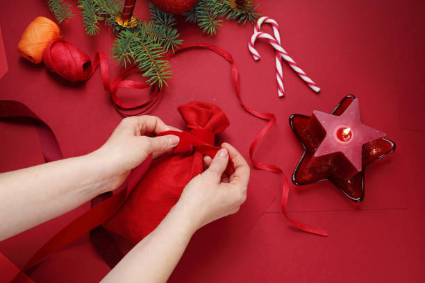 istock Christmas gift, woman wraps a present under the Christmas tree. 1191817225