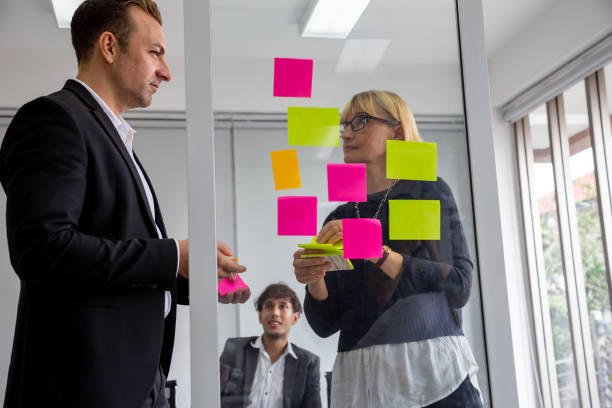 istock Businessman and Businesswoman tracking tasks on board. Using task control of agile development methodology in the office 1191817344