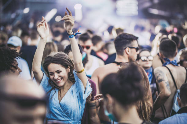 молодые счастливые друзья танцуют на музыкальном фестивал�е. - popular music concert crowd music festival spectator стоковые фото и изображения