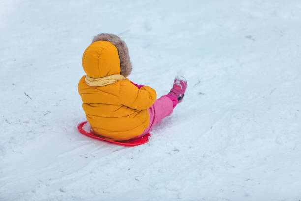 istock little kid at sledge sliding down by winter hill 1191819955