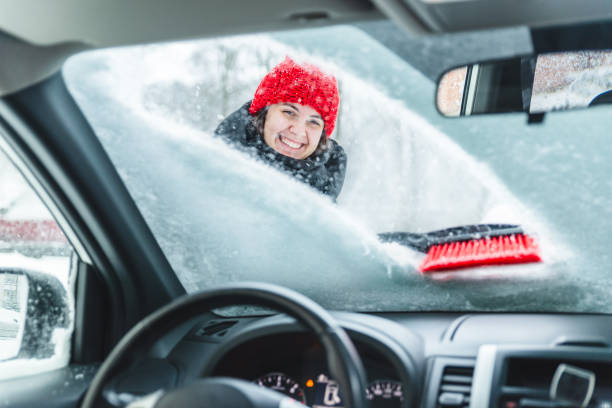 молодая красивая женщина уборка автомобиля после снежной бури - winter driving стоковые фото и изображения