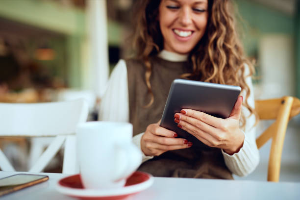 istock Attractive young curly brunette looking at her tablet and smiling 1191821111