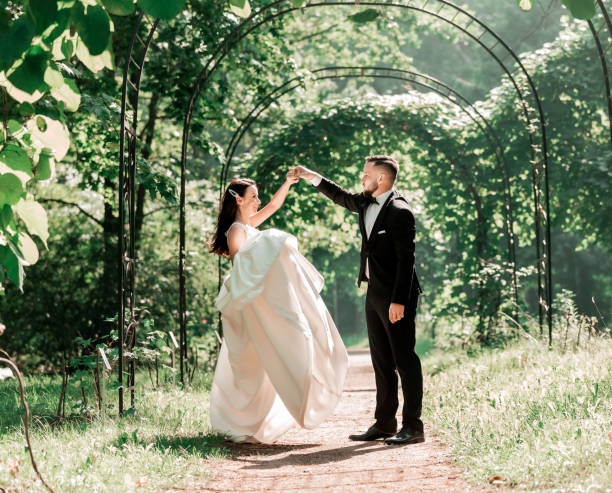 istock happy bride and groom dancing under the wedding arch. 1191827168