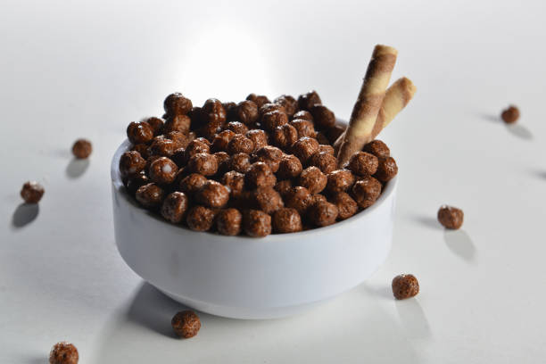 istock milk flowing in a bowl with chocolate cornflakes studio breakfast white background 1191829397