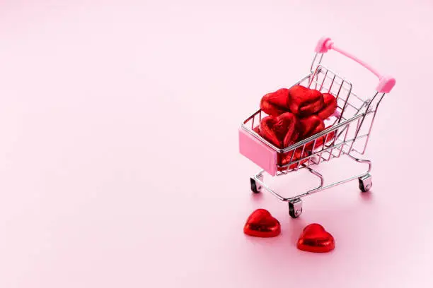 Chocolate Candy Shopping Cart heart on a pink background and space for text