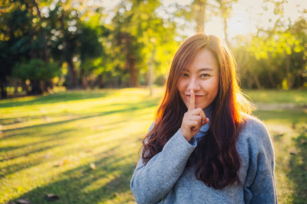 woman with index finger on lips, asking to be quiet or keep secret - keep quiet imagens e fotografias de stock