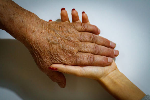 istock Old and Young Women Holding Hands 1191836675