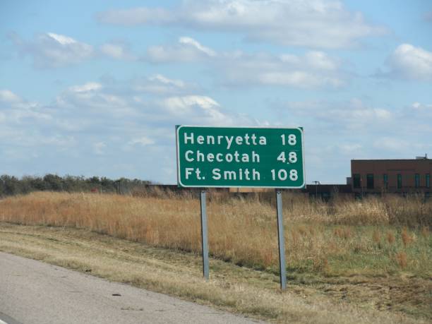 straßenschild mit entfernungen zu henryetta, chekotah und fort smith an der interstate 240 in oklahoma. - oklahoma sign road sign sky stock-fotos und bilder
