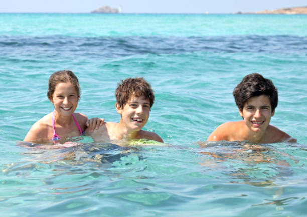 istock three smiling brothers in the clear water during a fun summer va 1191837521