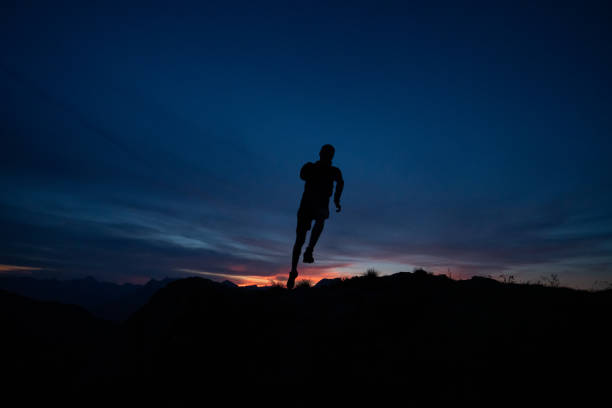 istock Trail runner runs along mountain ridge at sunrise 1191837545