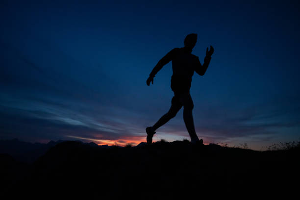 istock Trail runner runs along mountain ridge at sunrise 1191837618