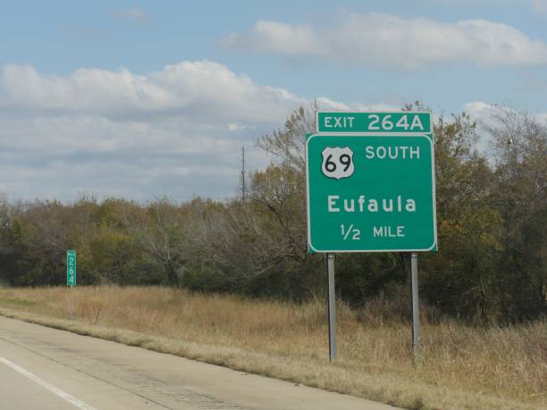 wegweiser mit entfernung nach eufala, oklahoma. - oklahoma sign road sign sky stock-fotos und bilder