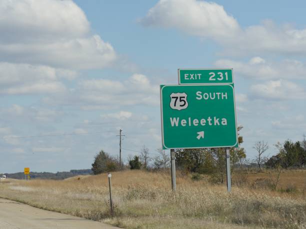 wegweiser mit wegbeschreibung nach weleetka, oklahoma am highway 75. - oklahoma sign road sign sky stock-fotos und bilder