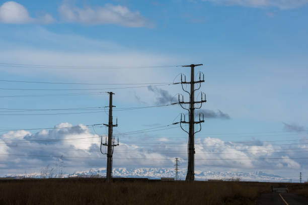 istock High voltage pylons on dry grassland 1191838716