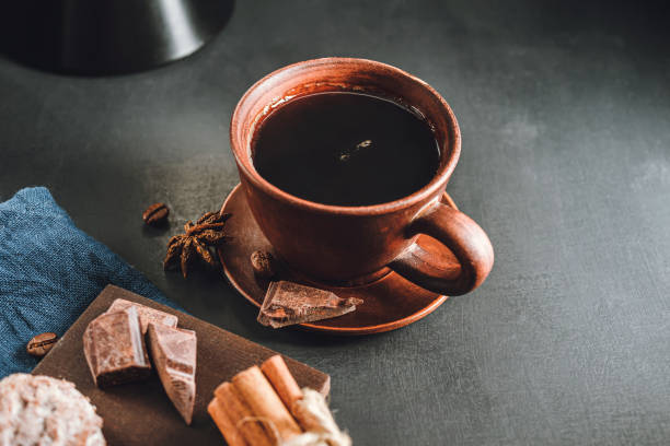 istock Brown cup with black coffee, chocolate pieces, star anise on dark background 1191838999