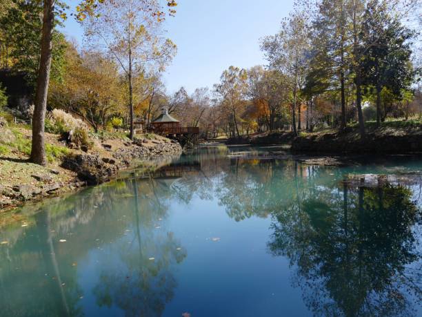istock Clear blue waters of a spring with colorful trees reflected 1191839258
